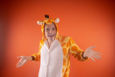 pijama bir zürafa şeklinde. turuncu bir arka plan üzerinde bir adam duygusal portresi. elbiseli çılgın ve komik adam. Çocuk partilerine için animatör