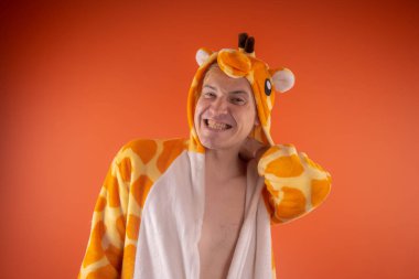 pijama bir zürafa şeklinde. turuncu bir arka plan üzerinde bir adam duygusal portresi. elbiseli çılgın ve komik adam. Çocuk partilerine için animatör