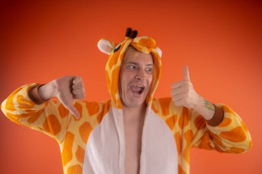 pijama bir zürafa şeklinde. turuncu bir arka plan üzerinde bir adam duygusal portresi. elbiseli çılgın ve komik adam. Çocuk partilerine için animatör