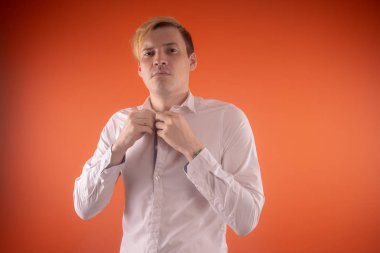 Yakışıklı genç adam düşünceli poz turuncu zemin üzerine beyaz gömlekli