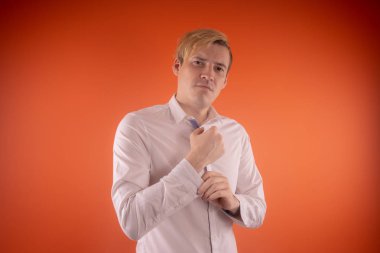 Yakışıklı genç adam düşünceli poz turuncu zemin üzerine beyaz gömlekli