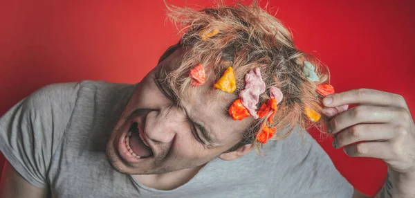Gum in his head. Portrait of man with chewing gum in his head. Man with hair covered in food. Closeup portrait of an angry  man who has opened a tin of food  and it has ended up in his hair , red back