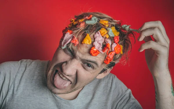 Gum in his head. Portrait of man with chewing gum in his head. Man with hair covered in food. Closeup portrait of an angry  man who has opened a tin of food  and it has ended up in his hair , red back