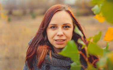 Kız sarı bir arka plan üzerinde sonbahar ağaçlarının yaprakları. Sonbahar fotoğraf oturumu. Açık havada yürüyen sonbahar kadın
