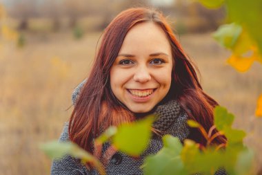 Kız sarı bir arka plan üzerinde sonbahar ağaçlarının yaprakları. Sonbahar fotoğraf oturumu. Açık havada yürüyen sonbahar kadın