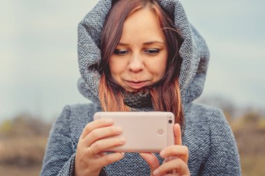 Genç kız selfie cep telefonu ile bir parkta yapma tarzı. Sonbahar sezonu zaman