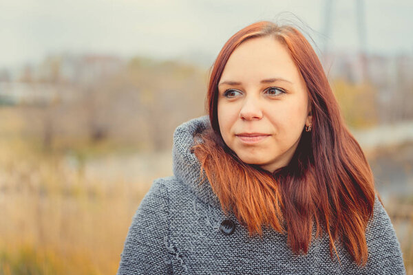 Girl on a background of yellow leaves of autumn trees. Autumn photo session. Autumn woman walking outdoors