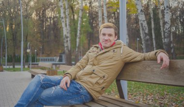 Sonbahar Park modern yakışıklı adam. Mevsimlik moda. Sonbahar stil. Arka plan Sonbahar Park genç bir adam portresi kapatın