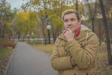 Sonbahar Park modern yakışıklı adam. Mevsimlik moda. Sonbahar stil. Arka plan Sonbahar Park genç bir adam portresi kapatın