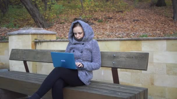 Egy Visel Egy Meleg Kapucnis Gépel Laptop Ősz Egy Padon — Stock videók