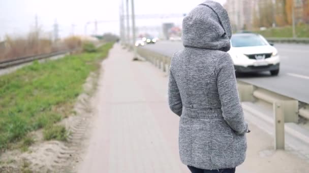 Young Girl Gray Coat Autumn Walks Fence Roadway — Stock Video