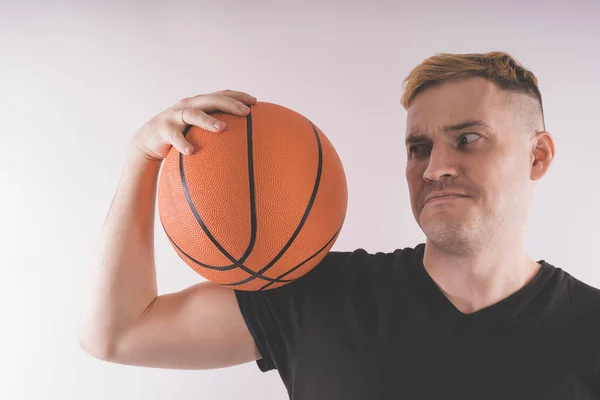 A guy with a basketball, a basketball player in training. The concept of sport and healthy lifestyle