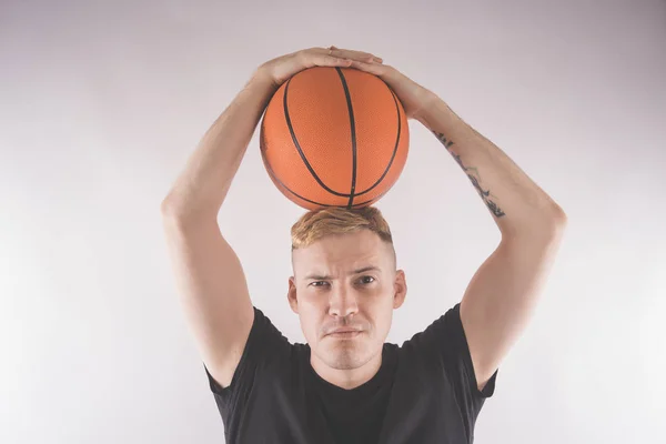 A guy with a basketball, a basketball player in training. The concept of sport and healthy lifestyle