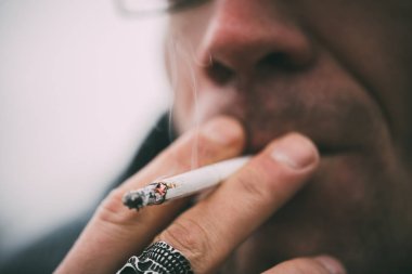 Bir adam sigara içiyor. Gözlüklü adam sigara içiyor. Tütün duman