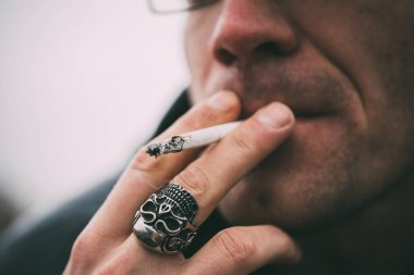 Bir adam sigara içiyor. Gözlüklü adam sigara içiyor. Tütün duman