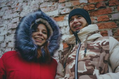 Arkadaşlar soğuk havalarda sıcak ceketler, arkadaşlık kavramı ısıtılan kadın toplantı iki kız bir yolda.
