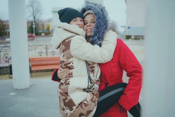 两个女孩在散步 在寒冷的天气里遇到朋友 女人穿着温暖的夹克热身 女性友谊的概念 — 图库照片
