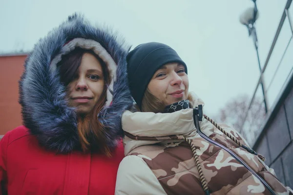 两个女孩在散步 在寒冷的天气里遇到朋友 女人穿着温暖的夹克热身 女性友谊的概念 — 图库照片