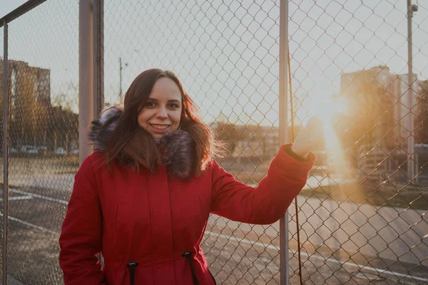 Счастливая Молодая Девушка Красной Куртке Позирует Улице Облачный День Эмоциональный — стоковое фото