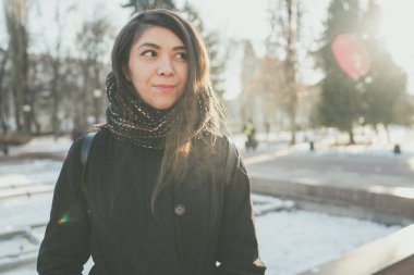 Kız Doğu Park'ta yürüyordunuz kışın görünüyor. Bir eşarp ile bir kış ceket giyen kadın. Sokak tarzı giyim