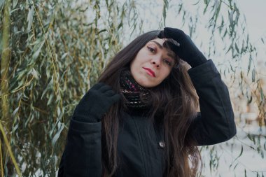 Kız Doğu Park'ta yürüyordunuz kışın görünüyor. Bir eşarp ile bir kış ceket giyen kadın. Sokak tarzı giyim