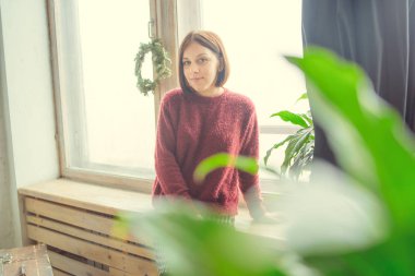 Pencerenin kız oturur, öğrenci düşünceli görünüyor. Model pencerenin önünde poz. Konsept: romantizm ve özlem