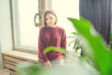 Pencerenin kız oturur, öğrenci düşünceli görünüyor. Model pencerenin önünde poz. Konsept: romantizm ve özlem