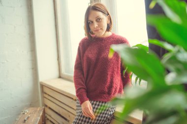 Pencerenin kız oturur, öğrenci düşünceli görünüyor. Model pencerenin önünde poz. Konsept: romantizm ve özlem