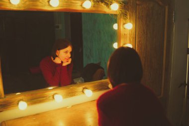 Kendisi de soyunma odasında aynada arayan genç kadın. Şık odaya poz güzel duygusallık kız.