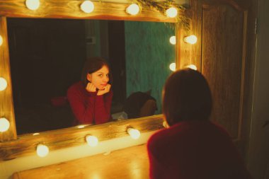 Kendisi de soyunma odasında aynada arayan genç kadın. Şık odaya poz güzel duygusallık kız.