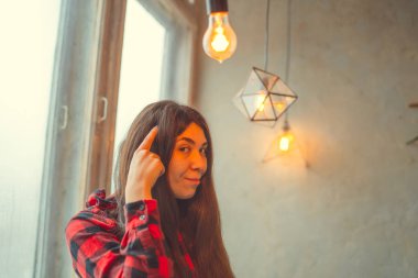 Pencerede, bir öğrenci bir gömlek içinde oturan kız. Model pencerenin önünde poz. Konsept: romantizm ve özlem