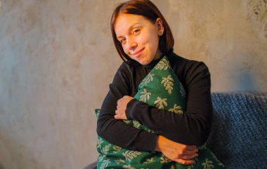 Ellerini sersem kanepede oturan bir yastık ile kız