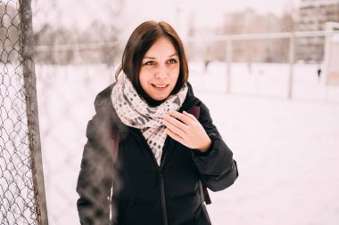 güzel bir sarışın bir şapka ve atkı soğuk sezonda şehir manzarası arka plan üzerinde portresi. sokakta yürüyen kız