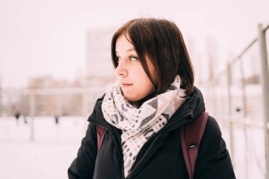 güzel bir sarışın bir şapka ve atkı soğuk sezonda şehir manzarası arka plan üzerinde portresi. sokakta yürüyen kız