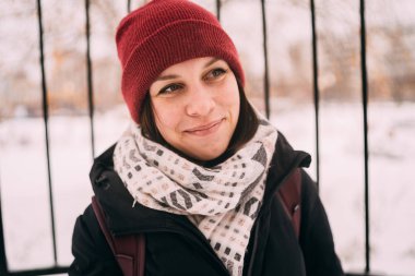 güzel bir sarışın bir şapka ve atkı soğuk sezonda şehir manzarası arka plan üzerinde portresi. sokakta yürüyen kız