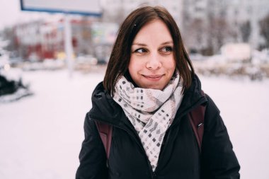 güzel bir sarışın bir şapka ve atkı soğuk sezonda şehir manzarası arka plan üzerinde portresi. sokakta yürüyen kız