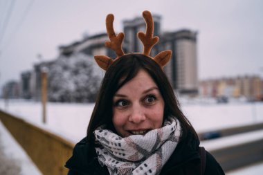 güzel bir sarışın bir şapka ve atkı soğuk sezonda şehir manzarası arka plan üzerinde portresi. sokakta yürüyen kız