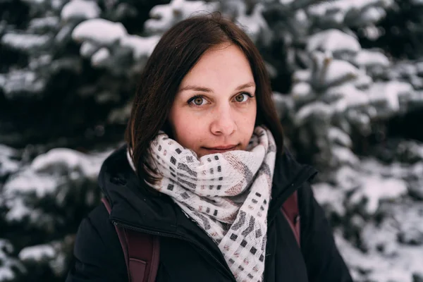 Kız kış ormanın içinde bir dinlenme var. Genç kadın kar kış parkta yürürken