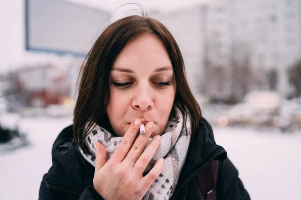 Girl smokes a cigarette. Woman  smokes cigarettes. Tobacco smoke