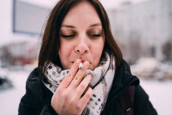 Girl smokes a cigarette. Woman  smokes cigarettes. Tobacco smoke