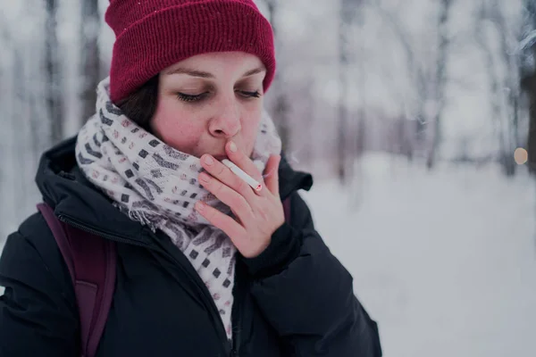 Girl smokes a cigarette. Woman  smokes cigarettes. Tobacco smoke