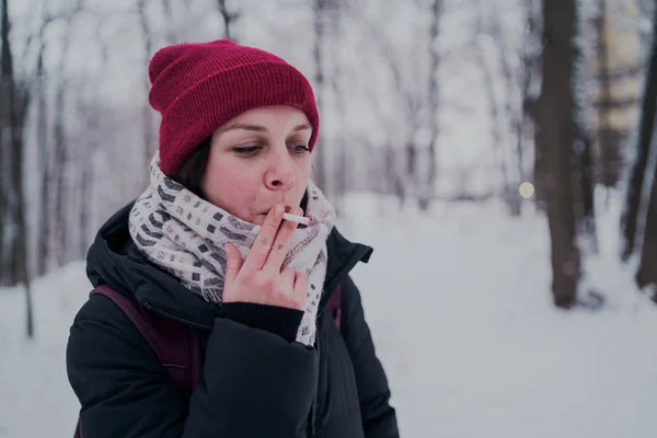 Girl smokes a cigarette. Woman  smokes cigarettes. Tobacco smoke