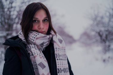 Kız kış ormanın içinde bir dinlenme var. Genç kadın kar kış parkta yürürken