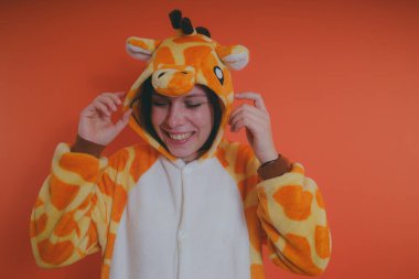 pijama bir zürafa şeklinde. duygusal portre turuncu bir arka plan üzerinde bir kız. takım elbiseli çılgın ve komik kız. Çocuk partilerine için animatör