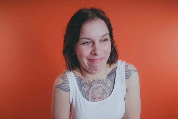 Meisje Met Een Tatoeage Haar Borst Poseren Een Oranje Achtergrond — Stockfoto