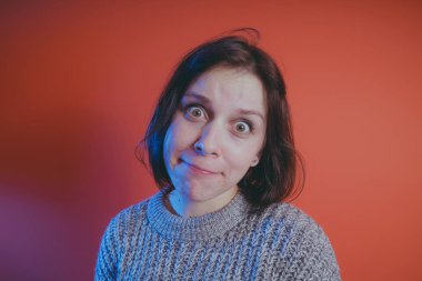 Genç kız sıcak gri süveterli kadın örme kazaklı kısa saç kesimi, metin için yer ile turuncu arka plan üzerinde poz