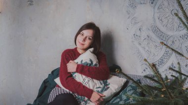 Ellerini sersem kanepede oturan bir yastık ile kız