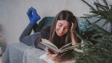 Rahat bir oda bir kitap okuma öğrenci. Bir kitap tutan kız. Konsept: kitap okuma