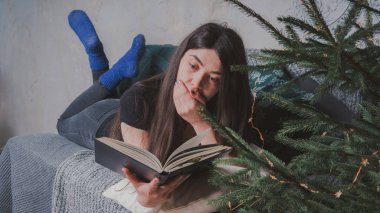 Rahat bir oda bir kitap okuma öğrenci. Bir kitap tutan kız. Konsept: kitap okuma