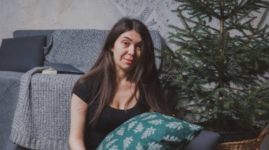 Kız sersem kanepe, rahat bir oda arka planı yakın katta oturuyor. Konsept: romantizm ve rüyalar